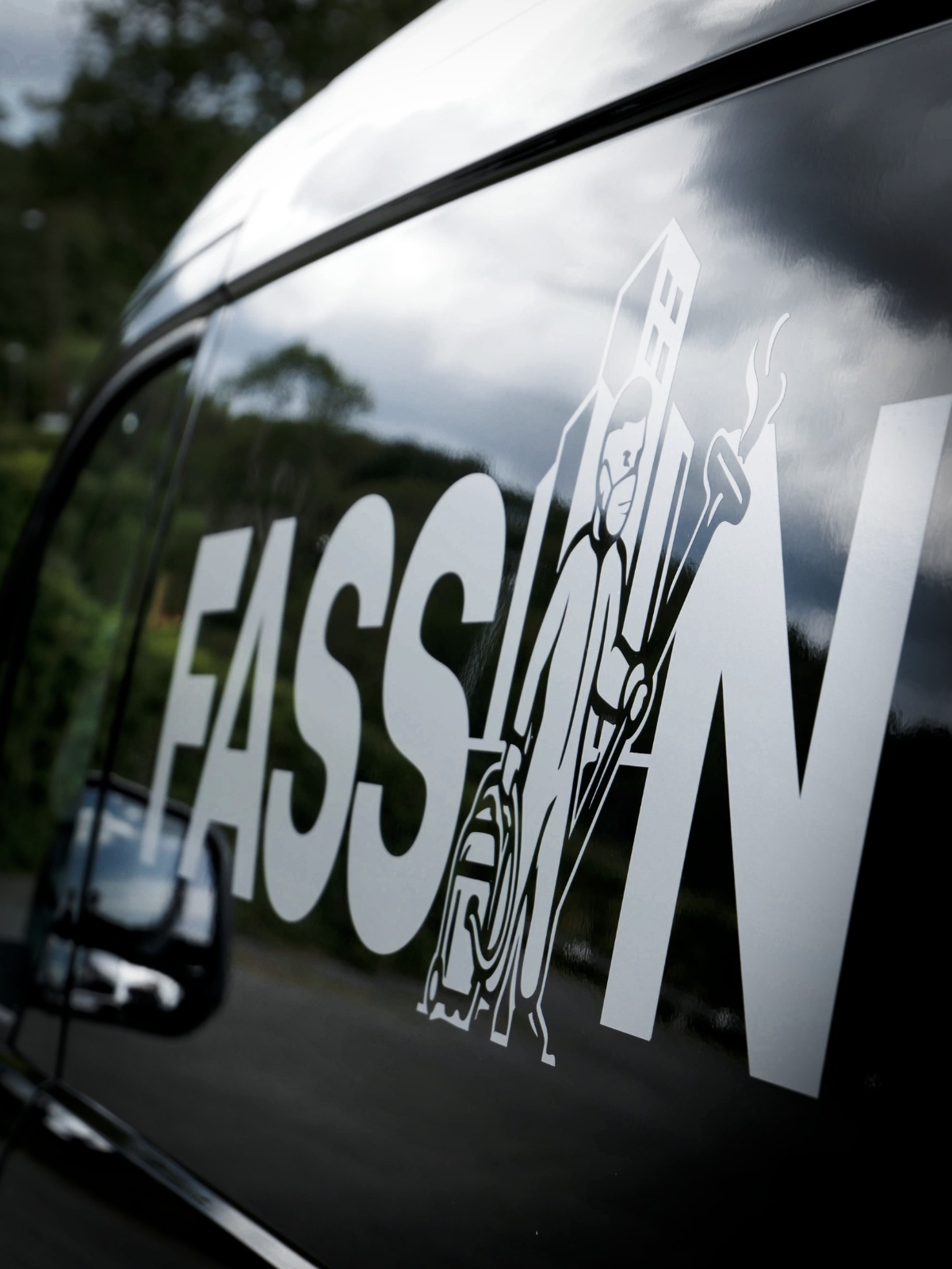 Närbild av FasSan-logotypen på företagets svarta servicebil